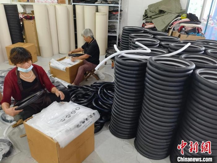 圖為村民在汽車飾品企業(yè)生產(chǎn)車間中工作。　呂子豪 攝