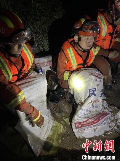 短暫修整期間，消防員脫掉鞋襪，用編織袋套住腿腳保暖。　閆旭輝 攝