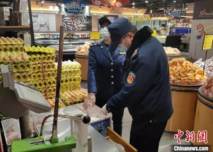 圖為疫情期間，甘肅嘉峪關(guān)市場監(jiān)管局工作人員檢查蔬菜市場。　 柴佳楠 　攝