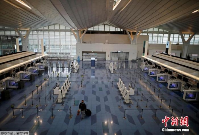 資料圖：日本東京，東京國際機(jī)場，一名乘客在國際航班航站樓的登機(jī)區(qū)。