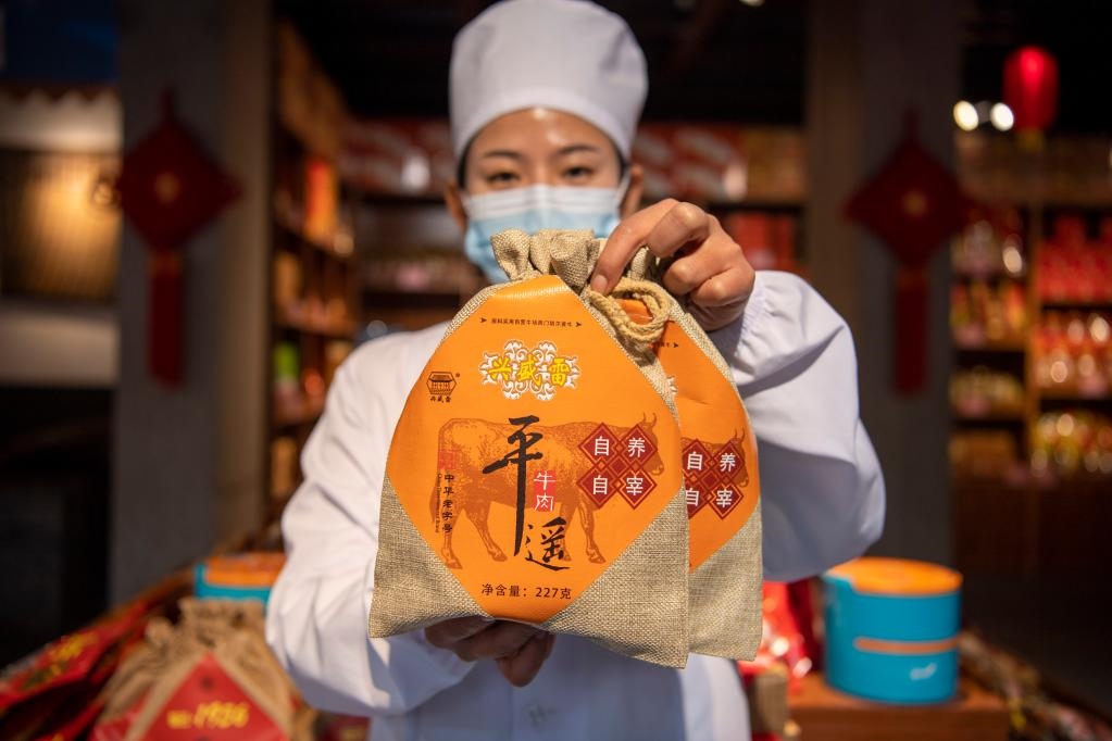 1月27日，在平遙古城南大街的一家平遙牛肉店內(nèi)，工作人員展示一款牛肉產(chǎn)品。新華社記者 楊晨光 攝