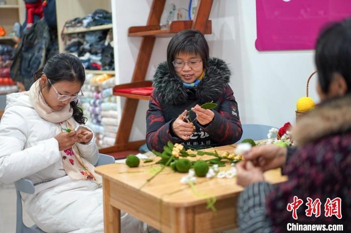 文創(chuàng)工作室的姐妹們正在鉤織月桂葉片。　古良駒 攝