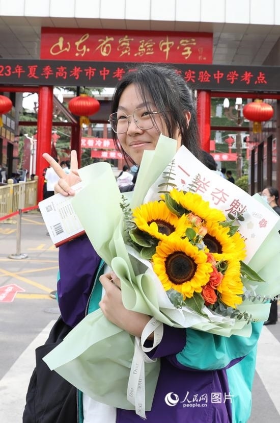 6月7日高考首日，山東67萬考生走進(jìn)考場(chǎng)，拼搏逐夢(mèng)。在山東省實(shí)驗(yàn)中學(xué)考點(diǎn)，考生進(jìn)考場(chǎng)前手捧向日葵花拍照留念，寓意“一舉奪魁”。人民網(wǎng)記者 劉祺攝