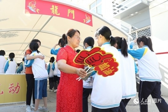 6月7日一早，雄安新區(qū)安新中學(xué)老師在給同學(xué)們加油鼓勁兒。人民網(wǎng) 李兆民攝