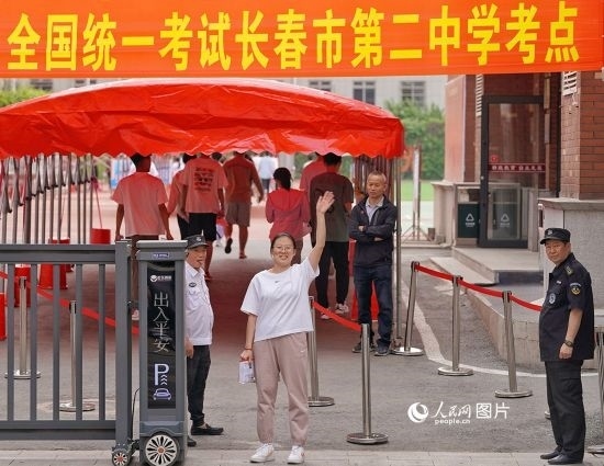 6月7日，在長春市第二中學(xué)考點(diǎn)，一名考生信心滿滿進(jìn)入考場(chǎng)，并與家長揮手致意。人民網(wǎng)記者 李洋攝