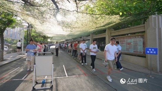 6月7日，烏魯木齊市第七十中學(xué)門口，考生們有序進(jìn)入考場(chǎng)。人民網(wǎng) 李欣洋攝