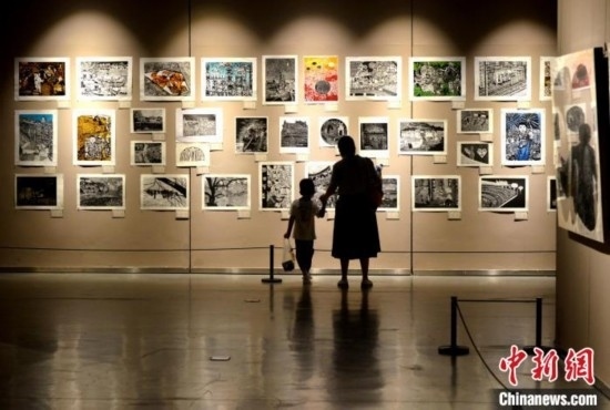 圖為家長(zhǎng)帶著孩子參觀展覽。呂明 攝