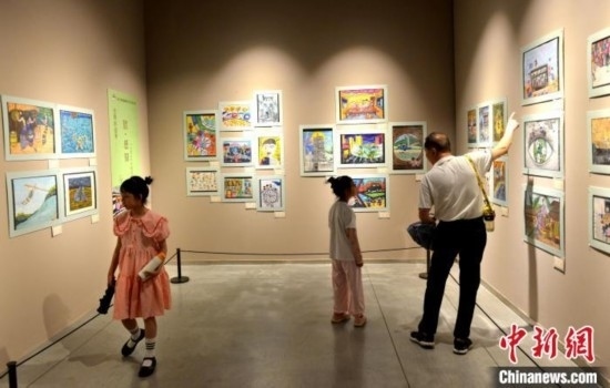 圖為家長(zhǎng)帶著孩子參觀展覽。呂明 攝