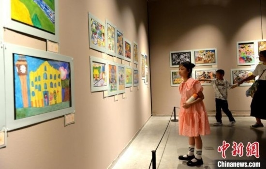 圖為家長(zhǎng)帶著孩子參觀展覽。呂明 攝