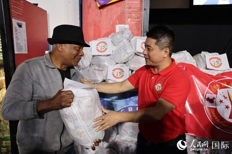 巴西中國浙江商會(huì)會(huì)長鄭俠茂向社區(qū)居民轉(zhuǎn)交捐贈(zèng)物資。人民網(wǎng)記者 時(shí)元皓攝