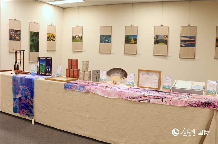 現(xiàn)場(chǎng)展出的馮學(xué)敏攝影作品與湖州市特色工藝品。（人民網(wǎng) 許可攝）