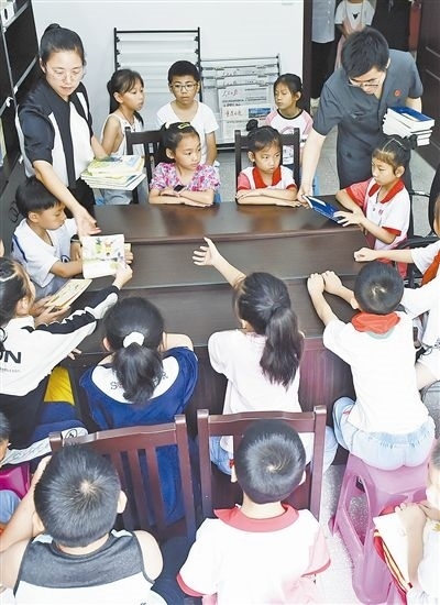  圖④：法院干警為留守兒童發(fā)放暑假讀物。