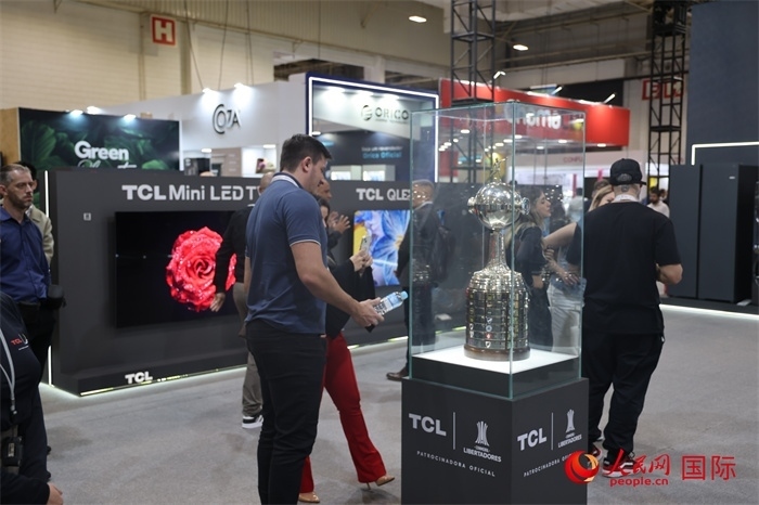 參觀者在TCL展臺(tái)前觀看南美解放者杯獎(jiǎng)杯，據(jù)介紹，TCL是南美解放者杯（2023—2026賽季）全球官方合作伙伴。（人民網(wǎng)記者 時(shí)元皓攝）