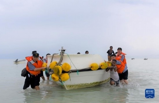 7月21日，中國海軍“和平方舟”號醫(yī)院船醫(yī)護(hù)人員涉水登島，前往基里巴斯一診療點。新華社記者 黎云 攝