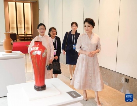 7月27日下午，國家主席習(xí)近平夫人彭麗媛在四川成都會見陪同印度尼西亞總統(tǒng)佐科來華出席第31屆世界大學(xué)生夏季運動會開幕式并訪華的總統(tǒng)夫人伊莉亞娜。這是彭麗媛和伊莉亞娜欣賞成都特色非遺工藝品。新華社記者 丁林 攝