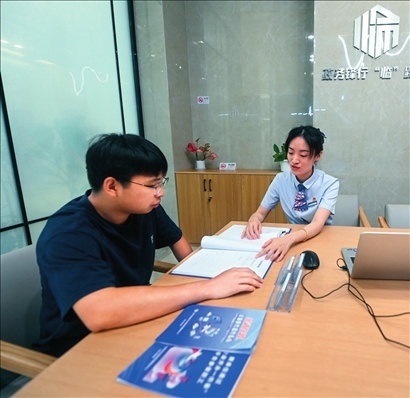 在杭州市臨安區(qū)政務服務中心的“為企服務中心”，黨員志愿者（右）解答企業(yè)主的疑問（2023年7月7日攝）。徐昱攝/本刊