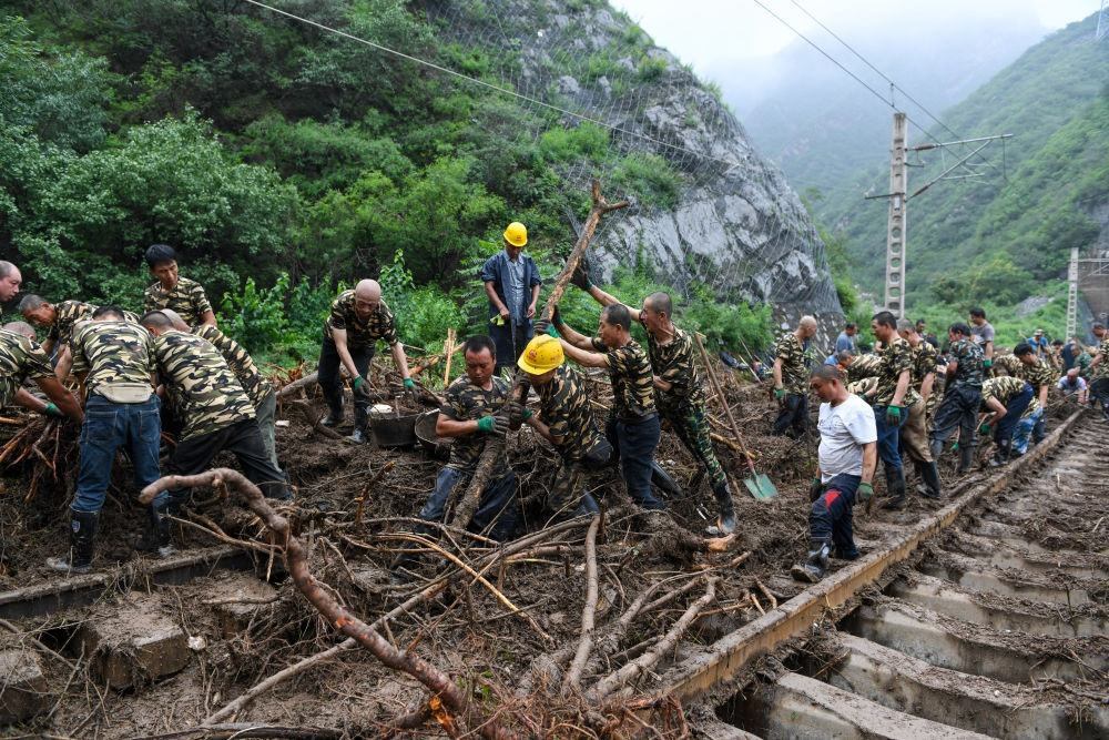 8月1日，在北京市門頭溝區(qū)水峪嘴村附近一段被阻斷的鐵路線上，中鐵六局工作人員在清理軌道上的雜物，全力恢復(fù)交通。新華社記者 鞠煥宗 攝