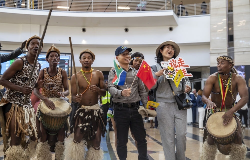 在南非約翰內斯堡坦博國際機場，南非舞蹈演員歡迎中國試點恢復出境團隊旅游后首批抵達南非的中國游客（2023年3月29日攝）。