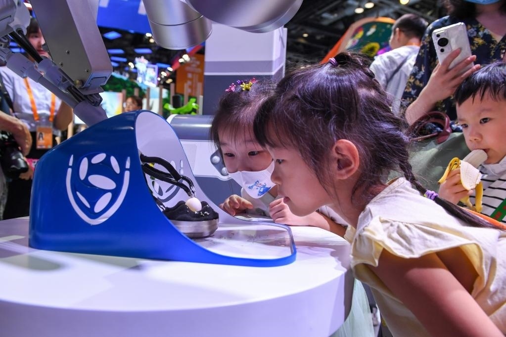 9月3日，幾名小朋友在國(guó)家會(huì)議中心觀看單孔腔鏡手術(shù)機(jī)器人展示。新華社記者 鞠煥宗 攝