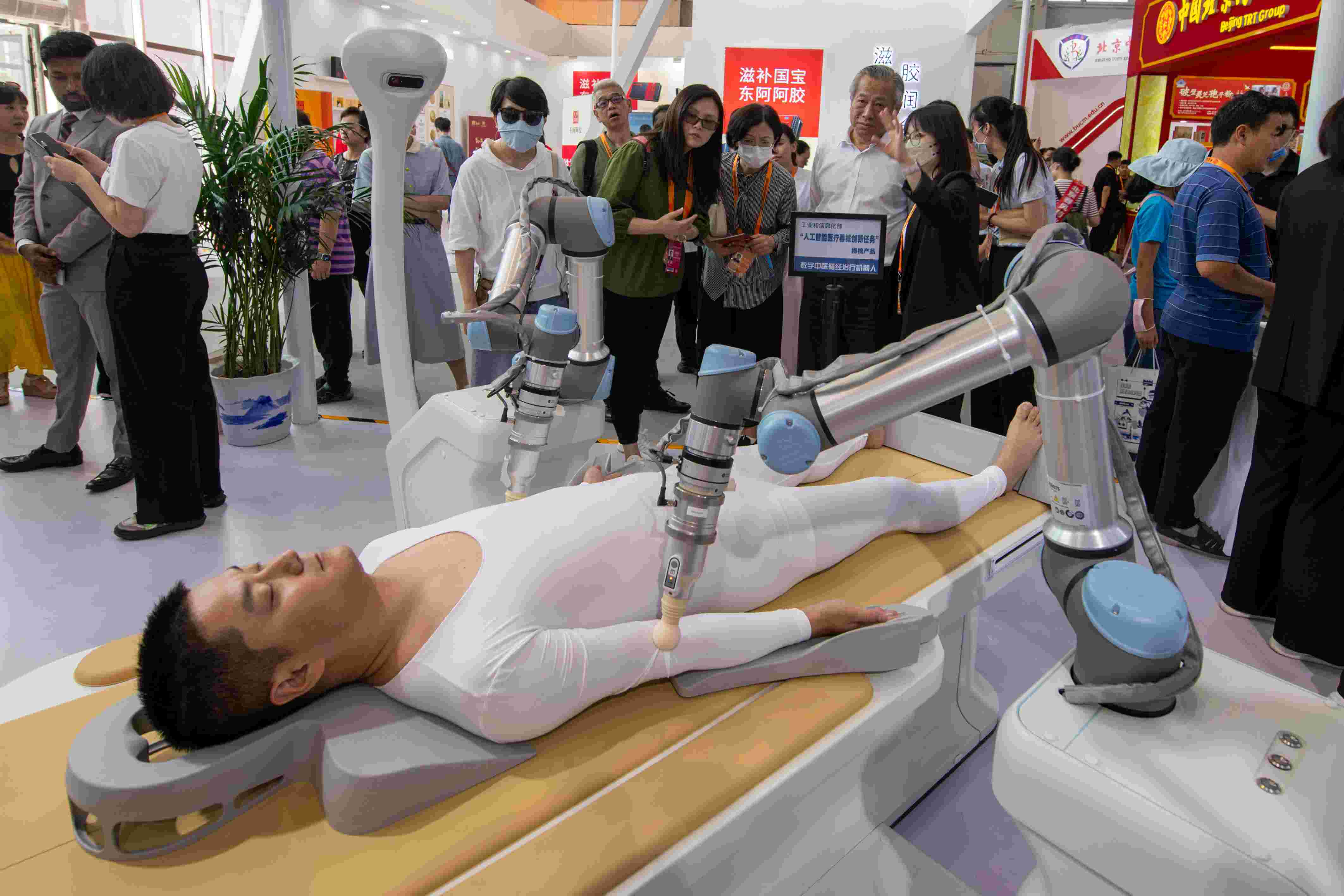 在位于首鋼園的健康衛(wèi)生服務(wù)展區(qū)，觀眾正在參觀數(shù)字中醫(yī)循經(jīng)治療機(jī)器人。人民網(wǎng)記者 翁奇羽攝