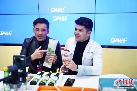 2023年3月，甘肅省慶陽市環(huán)縣電商創(chuàng)業(yè)孵化基地內(nèi)，來自蘭州文理學院的塔吉克斯坦留學生正在協(xié)助主播直播帶貨當?shù)剞r(nóng)特產(chǎn)品。李亞龍 攝