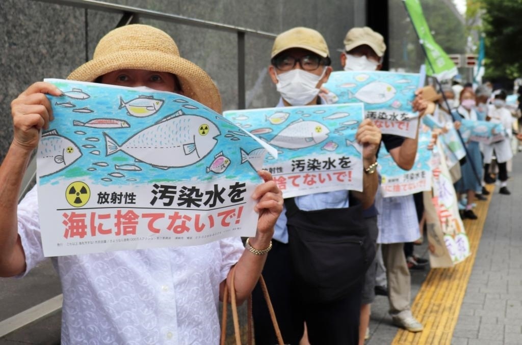 8月24日，日本民眾手持“不要將污染水扔進大?！钡葮苏Z在東京電力公司總部前集會，抗議日本政府和東電公司無視民意啟動核污染水排海。新華社記者楊光攝