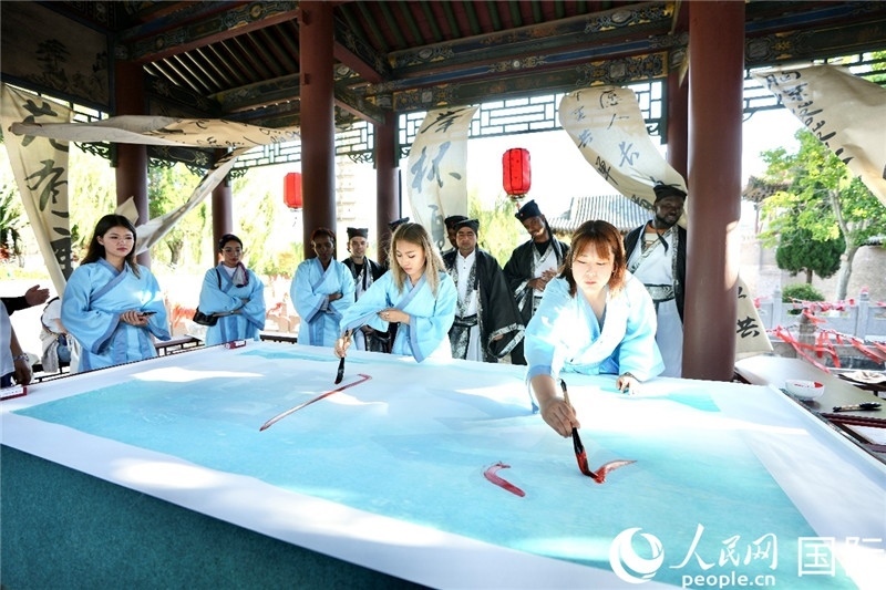 選手們提筆書寫“家園”二字。人民網(wǎng) 盧鵬宇攝