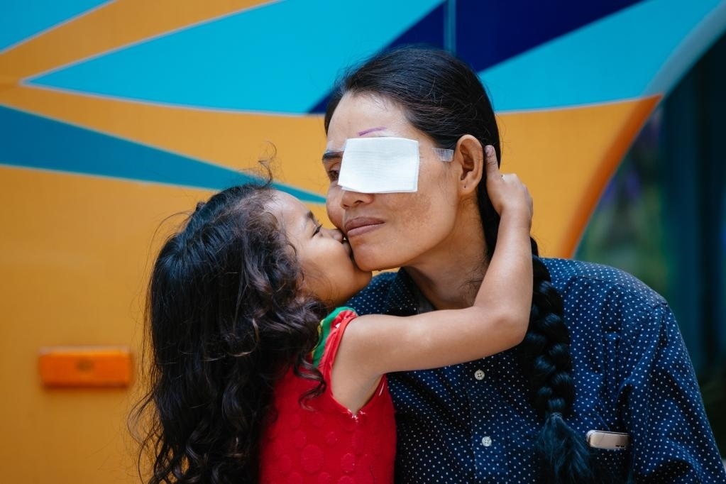 2019年3月15日，在柬埔寨磅湛省醫(yī)院，即將接受白內(nèi)障手術(shù)的患者孫美樂接受女兒的親吻祝福。在接受了中國醫(yī)療隊的白內(nèi)障義診手術(shù)后，她的視力逐步恢復(fù)，生活有了新的光明和希望。