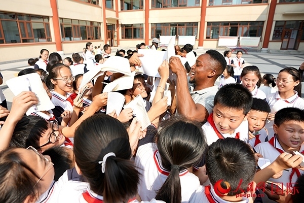 孩子們和選手互動(dòng)簽名。人民網(wǎng) 盧鵬宇攝