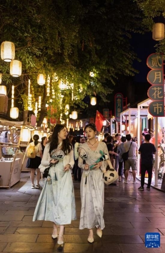 在成都寬窄巷子，兩位來(lái)自安徽的游客在新“十二月市”街區(qū)游覽（9月29日攝）。