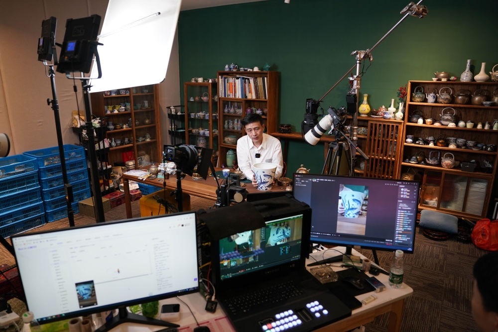 ↑在景德鎮(zhèn)，工作人員通過(guò)網(wǎng)絡(luò)直播推介陶瓷產(chǎn)品（2023年2月22日攝）。