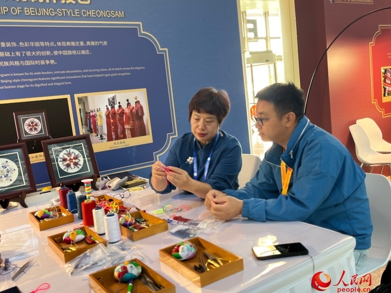 記者在新聞中心非遺傳承人展區(qū)進(jìn)行體驗(yàn)。人民網(wǎng)記者 杜燕飛攝