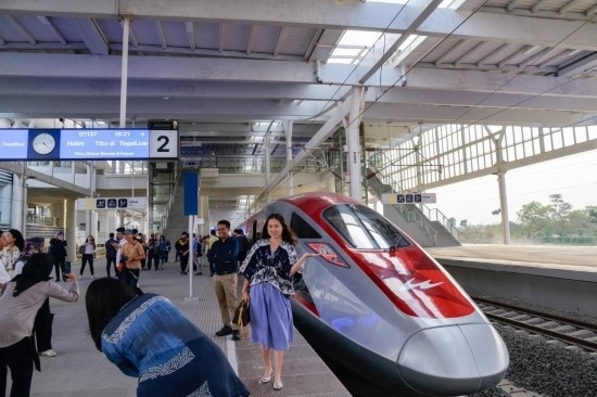  10月17日，在印度尼西亞萬隆德卡魯爾站，乘客在站臺上和雅萬高鐵高速動車組列車合影。新華社記者 徐欽 攝