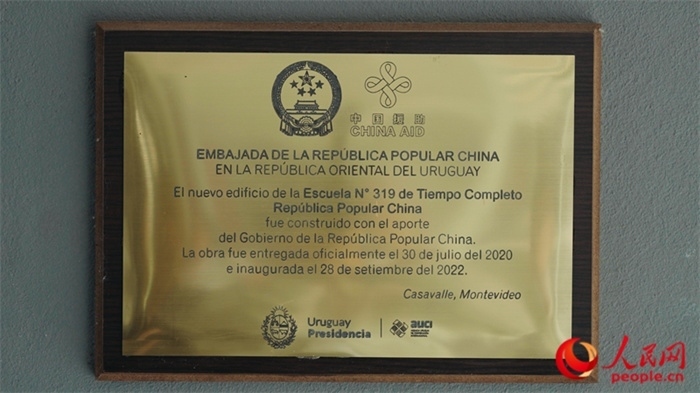 小學(xué)墻上懸掛的中國援助標識。人民網(wǎng)記者 張若涵攝