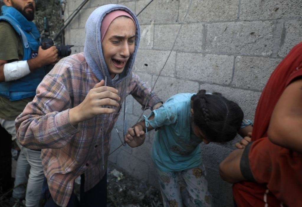 11月6日，人們從加沙地帶中部地區(qū)一處被炸難民營逃離。新華社發(fā)（亞西爾·庫迪攝）