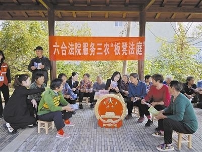  圖③：干警向附近農(nóng)戶解讀相關(guān)法律法規(guī)。