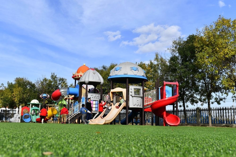 在山東省東營市墾利區(qū)楊廟社區(qū)幼兒園，孩子們在老師的帶領下進行戶外活動（2021年10月19日攝）。新華社記者 郭緒雷 攝