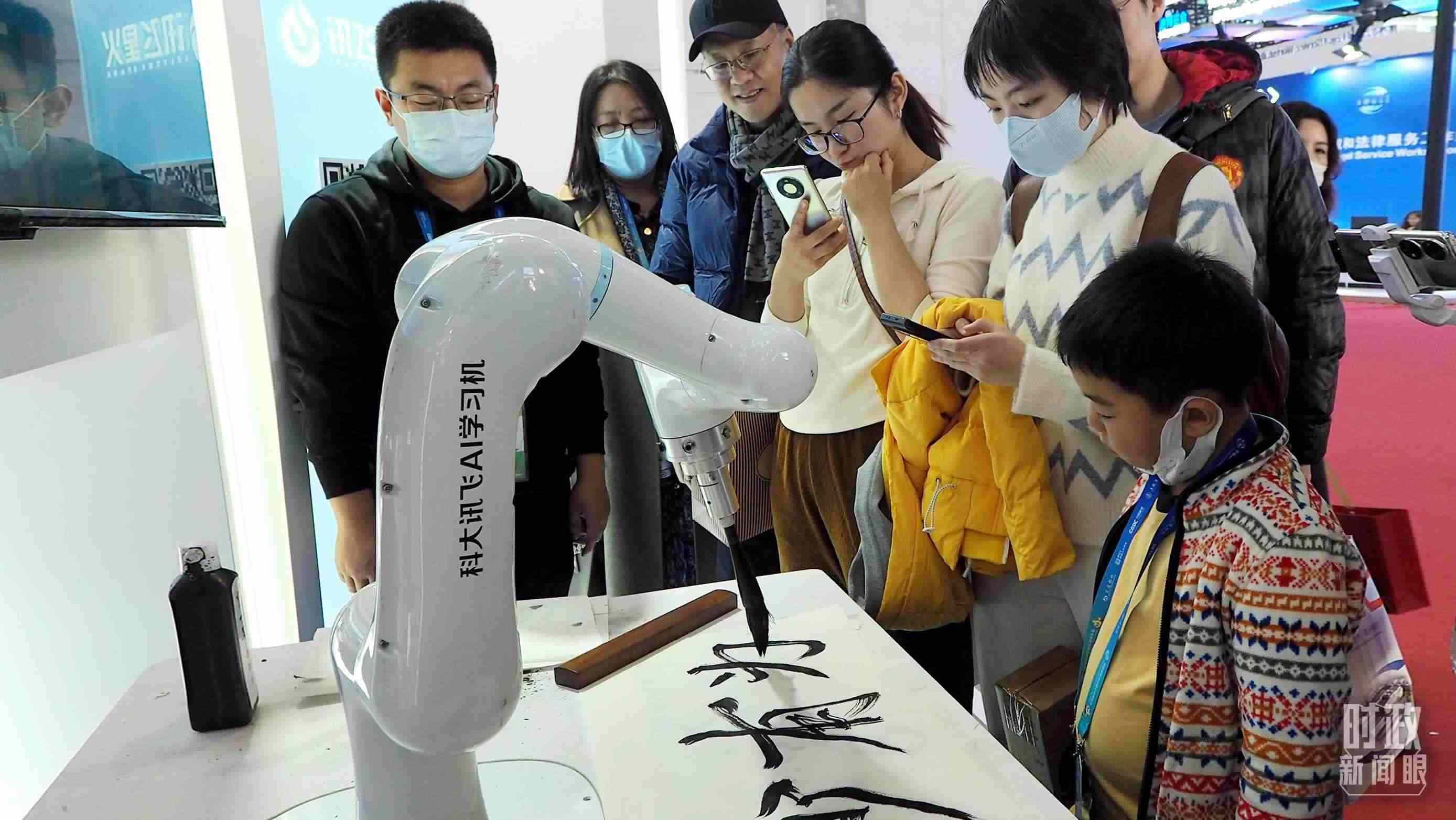 △觀眾在首屆鏈博會(huì)上體驗(yàn)AI書法機(jī)器人。