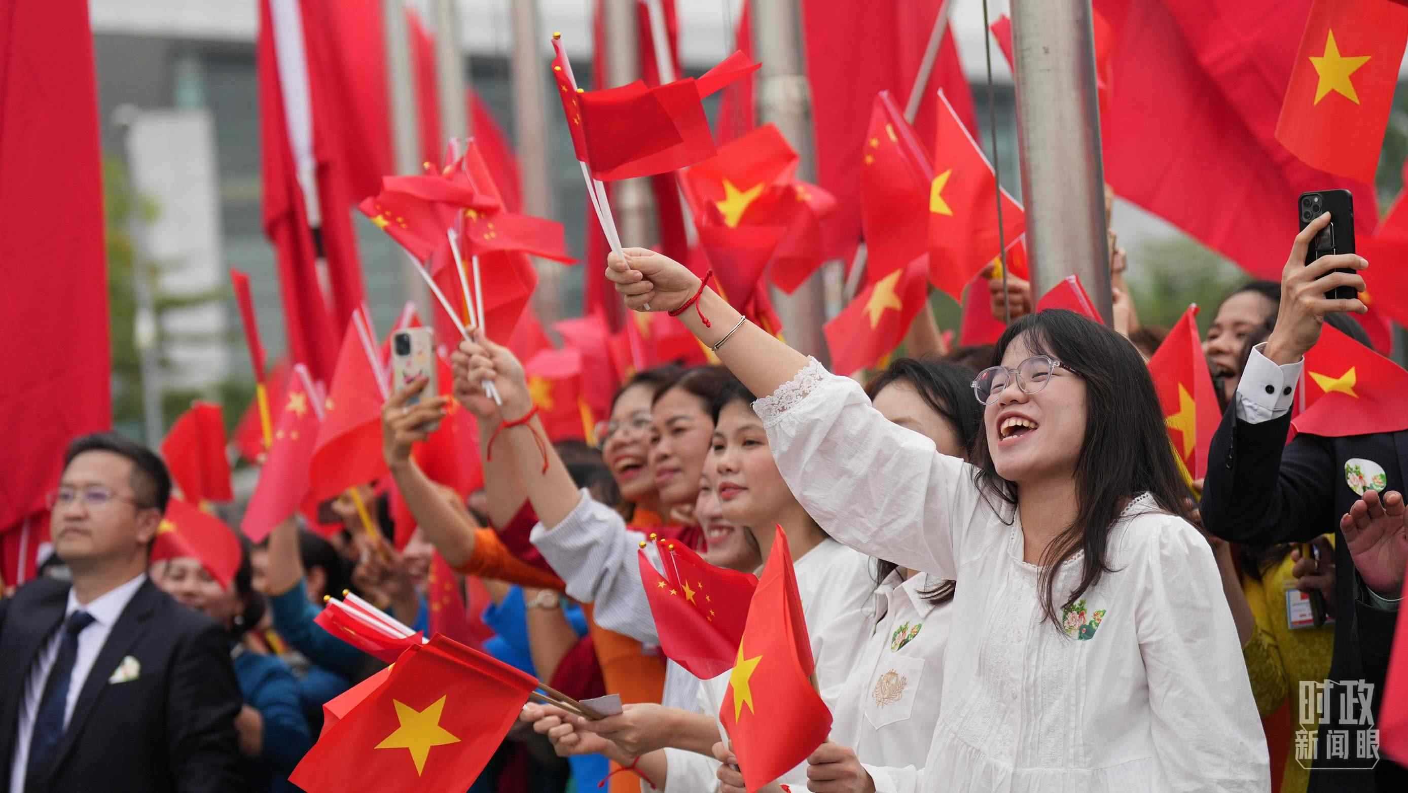 △人們揮舞兩國旗幟歡迎習(xí)近平訪越。（總臺(tái)國廣記者李晉拍攝）