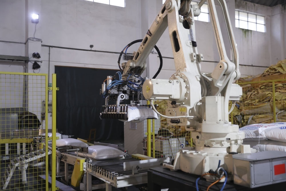 12月14日，在廣西來(lái)賓東糖鳳凰有限公司，機(jī)械臂在廠房碼放白砂糖成品。