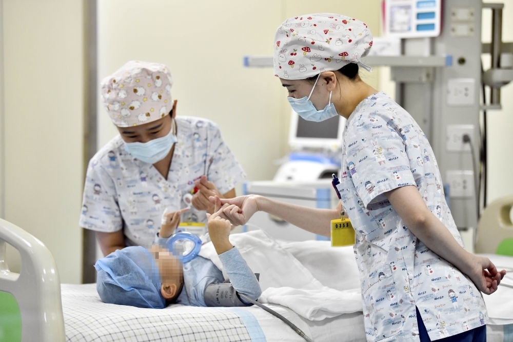 在山東省棗莊市婦幼保健院兒童ICU病房，醫(yī)護(hù)人員為完成靶向治療藥物諾西那生鈉的4歲脊髓性肌萎縮癥患兒加油鼓勁（2022年1月1日攝）。諾西那生鈉注射液是我國首個獲批治療脊髓性肌萎縮癥的進(jìn)口藥物，2019年進(jìn)入中國市場時，每針價格近70萬元。在2021年國家醫(yī)保目錄藥品談判中，以3.3萬元每針的價格進(jìn)入新版醫(yī)保藥品目錄。新華社記者 郭緒雷 攝