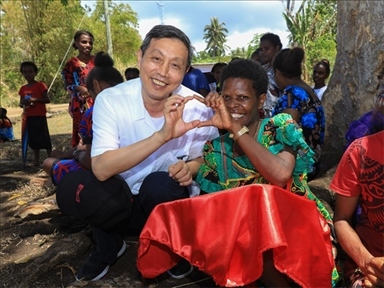 2023年12月18日，中國駐瓦努阿圖大使李名剛和前來觀看瓦努阿圖公路項目二期馬勒庫拉段移交儀式的當(dāng)?shù)鼐用窈嫌?。人民網(wǎng) 賀吉攝