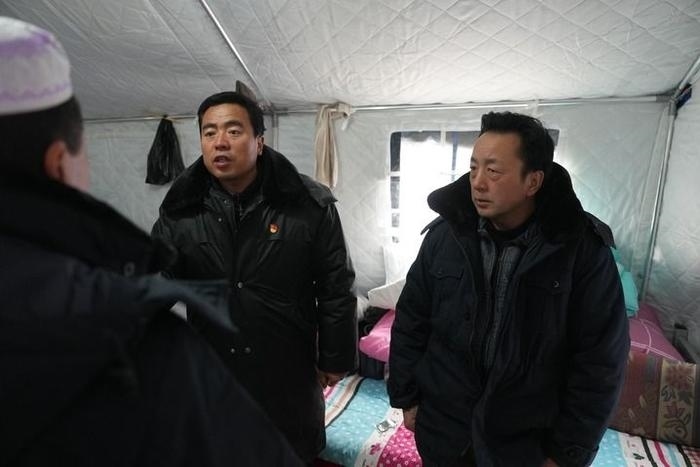 2023年12月22日，積石山縣大河家鎮(zhèn)大河村黨支部書記馬成忠（右二）在帳篷里和受災(zāi)群眾交流。新華社記者 陳斌 攝