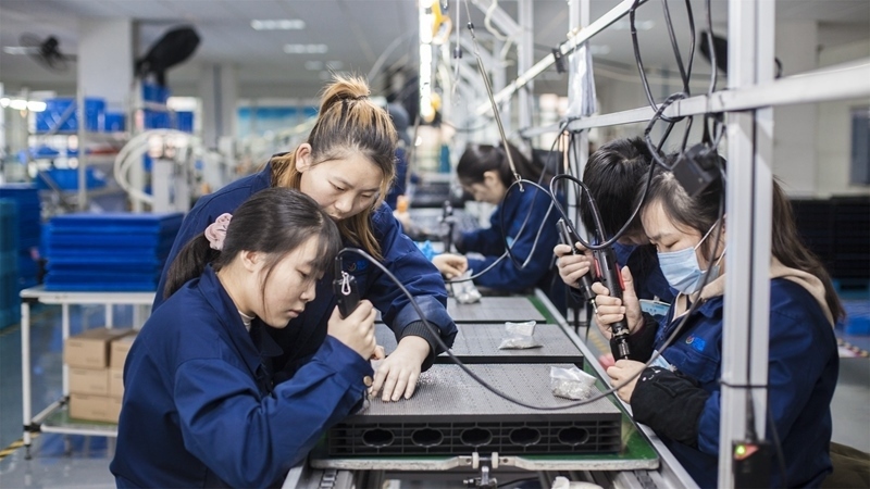 在新亞勝光電的產(chǎn)品線上，工人正進行產(chǎn)品組建和安裝布線。受訪者供圖