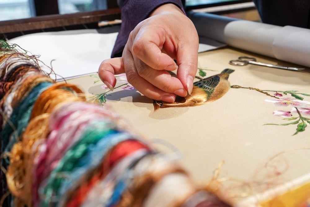 △2023年7月6日，盧建英在江蘇蘇州平江路的工作室內(nèi)刺繡。