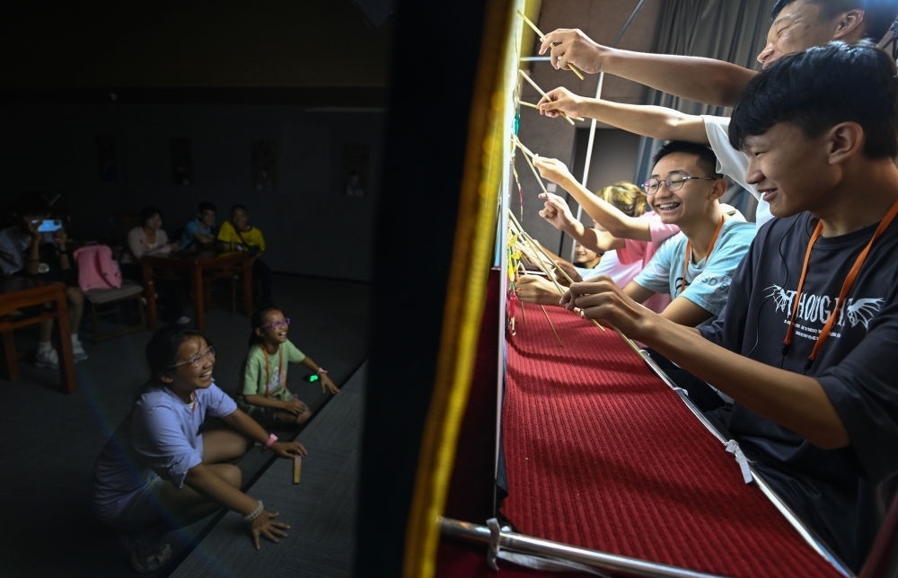 2023年8月8日，進行暑期研學的學生在位于陜西省西安市的中國秦腔藝術博物館體驗皮影戲演出。新華社記者 鄒競一 攝