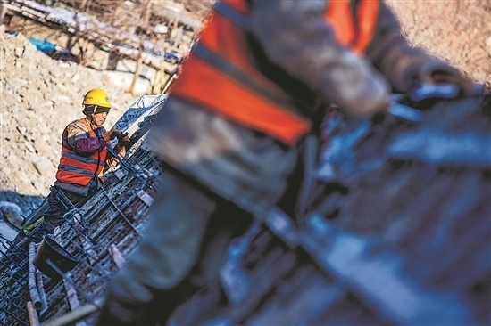 1月3日，房山區(qū)，工人正在雙泉河修筑堤壩。