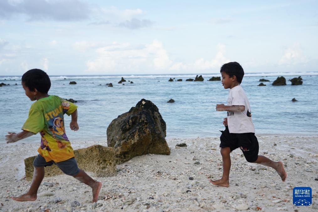 1月20日，兒童在瑙魯海邊嬉戲。新華社記者 王申 攝