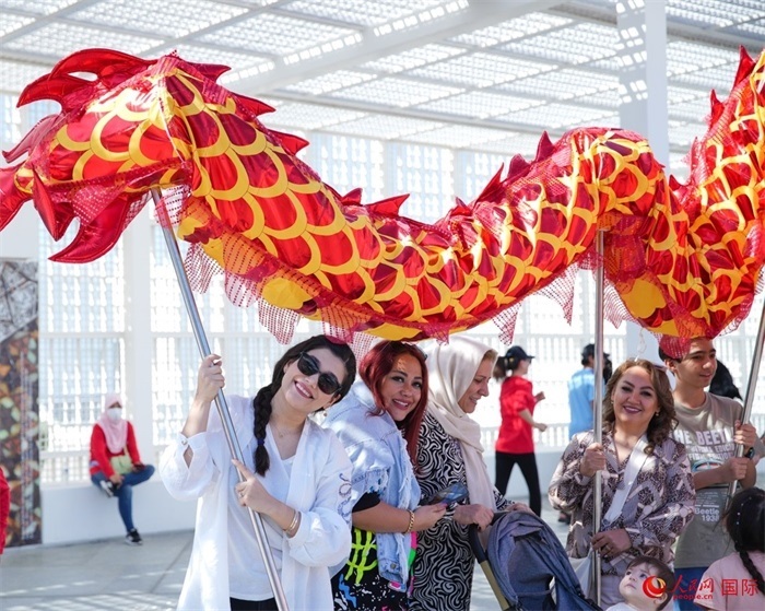 游客體驗(yàn)舞龍。 人民網(wǎng) 塔里克·易卜拉欣攝