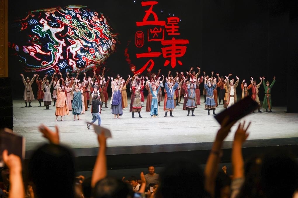 2023年7月31日，新疆和田地區(qū)新玉歌舞團(tuán)在烏魯木齊京劇院演出舞劇《五星出東方》后和觀眾互相揮手致意。這場(chǎng)演出是第六屆中國(guó)新疆國(guó)際民族舞蹈節(jié)的參演劇目之一，曾榮獲國(guó)家“文華獎(jiǎng)”等。新華社記者 郝昭 攝